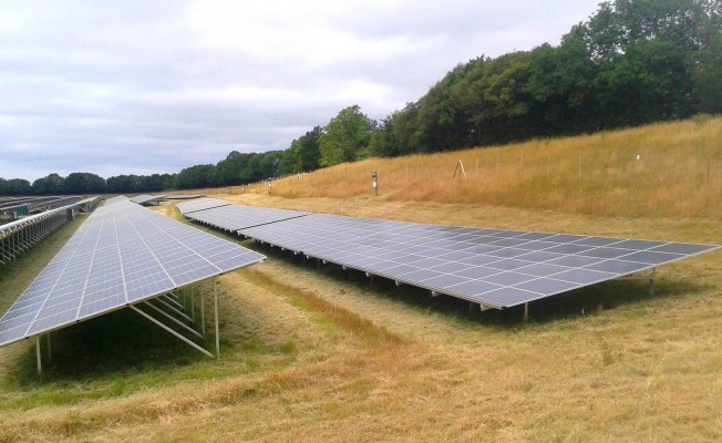 Solar farm near Cambridge on a cloudy summer day working at full capacity