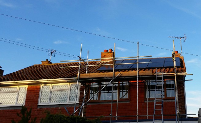 Three large and four small solar panels installed on a box gable type roof in Cambridge