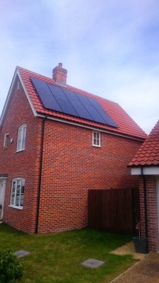 Large red brick semi-detached house with a set of ten solar panels near Cambridge